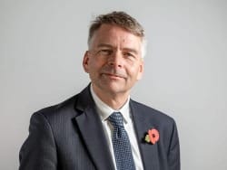 Cllr Andrew Gant, Cabinet Member for Transport Management, Oxfordshire County Council smiling at camera wearing grey suit